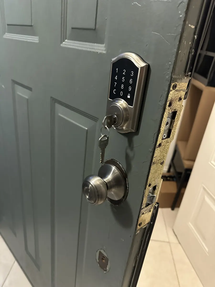Touchscreen keypad deadbolt and knob on a gray entry door in Coral Springs